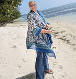 Designer Gwendolyn Gleason on the beach in the Maldives modeling the desert flower artisan block print hankerchief jacket  in blue/white/aqua.